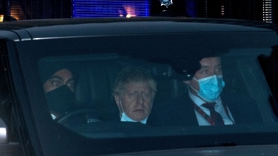 Britain's Prime Minister Boris Johnson wearing a face covering but pulled down under his chin, sits in the back of a car as he is driven away from the Houses of Parliament. (Representative image/AFP)