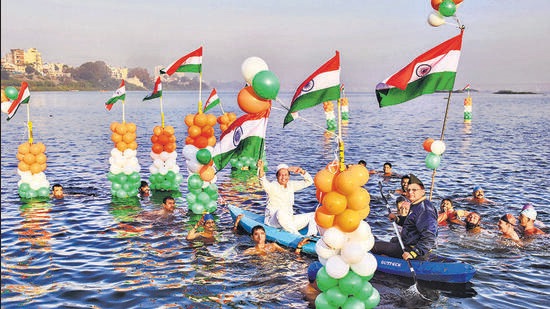 Surat: People hold the national flags as they swim in the Tapi river to celebrate Republic Day, in Surat, Wednesday, January 26, 2022. (PTI Photo) (PTI01_26_2022_000272B) (PTI)