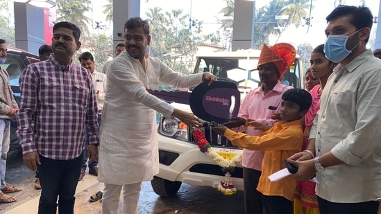 Anand Mahindra took to Twitter to share this image of the man who created a vehicle from scraps receiving a car as a gift.(Twitter/@anandmahindra)