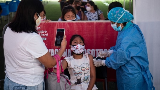 A health worker inoculates a child in Peru's Lima. (AFP) A health worker inoculates a child in Peru's Lima. (AFP)