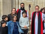 In this undated photo, Indian-origin Reverend Saju with his wife and children holding a staff made of Indian rosewood after a consecration ceremony at St. Paul's Cathedral in London. (PTI Photo) In this undated photo, Indian-origin Reverend Saju with his wife and children holding a staff made of Indian rosewood after a consecration ceremony at St. Paul's Cathedral in London. (PTI Photo)