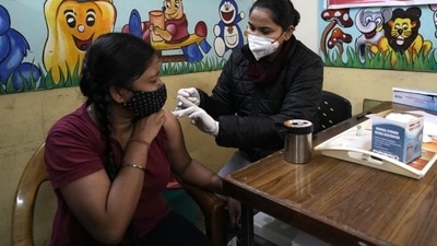 A health worker administers Covid-19 vaccine at a government school in New Delhi. (AP) A health worker administers Covid-19 vaccine at a government school in New Delhi. (AP)