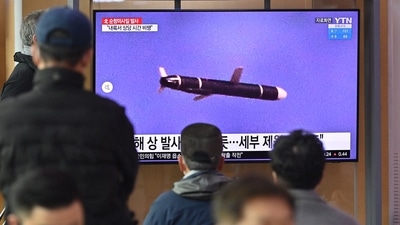 People watch a television screen showing a news broadcast with file footage of a North Korean missile test. (AFP) People watch a television screen showing a news broadcast with file footage of a North Korean missile test. (AFP)