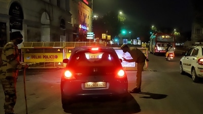 Delhi Police personnel stop a vehicle during a weekend curfew imposed by the Delhi government amid rising Covid-19 cases. Delhi Police personnel stop a vehicle during a weekend curfew imposed by the Delhi government amid rising Covid-19 cases.