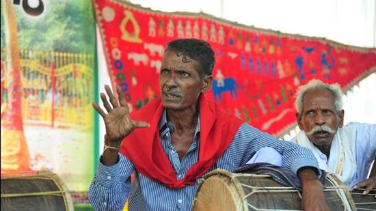 Sakine Ramachandraiah has mastered the art of singing about the history of the tribals, which are inscribed in the form of signs and pictures on ‘Pagide’ or ‘Dolu gudda’, a conic shaped red-coloured cloth of 6-10 metres in size. (HT Archives)