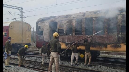 Railway Protection Force (RPF) personnel in action after two boogies of an empty train were set on fire by the railway job aspirants in Gaya on Wednesday. (Santosh Kumar/HT Photo)