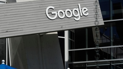 People walk by a Google sign on the company's campus in Mountain View, California People walk by a Google sign on the company's campus in Mountain View, California