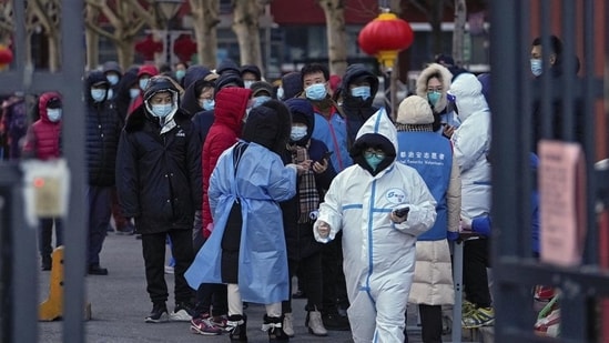Residents wearing masks to help protect from the coronavirus gather in line as they wait for a throat swab at a Covid-19 test site outside a residential housing block in Fengtai district in Beijing, China on Wednesday.(Representative image/AP)
