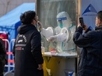 A man uses a smartphone to record residents getting a throat swab at a mass coronavirus test site in Xichen District in Beijing.(AP) A man uses a smartphone to record residents getting a throat swab at a mass coronavirus test site in Xichen District in Beijing.(AP)