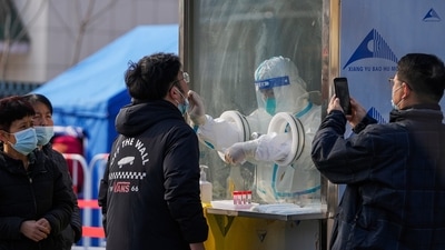 A man uses a smartphone to record residents getting a throat swab at a mass coronavirus test site in Xichen District in Beijing. (AP) A man uses a smartphone to record residents getting a throat swab at a mass coronavirus test site in Xichen District in Beijing. (AP)