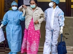 Health workers help a patient after her discharge from a state government-run Covid-19 hospital.(PTI) Health workers help a patient after her discharge from a state government-run Covid-19 hospital.(PTI)
