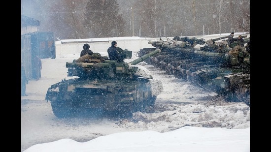 Ukrainian Military Forces servicemen manoeuvre in front of tanks of the 92nd separate mechanised brigade of Ukrainian Armed Forces, parked in their base near Klugino-Bashkirivka village, in the Kharkiv region on January 31, 2022 (AFP)