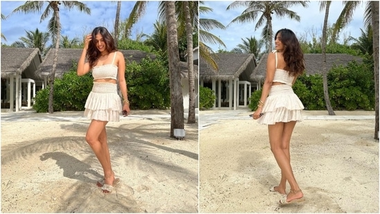 Malavika slipped into a co-ord bralette and mini skirt set for enjoying a sunny day at the beach. She wore an off-white smocked top with a square neckline, thin straps, and midriff-baring cropped hem.(Instagram/@malavikamohanan_)