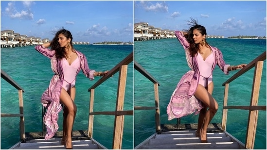 This third look shows Malavika making a statement in a purple monokini featuring a plunging V neckline and high-rise leg cuts. She layered the swimsuit with a purple coverup featuring an open front, a fabric belt tie and Aztec prints.(Instagram/@malavikamohanan_)