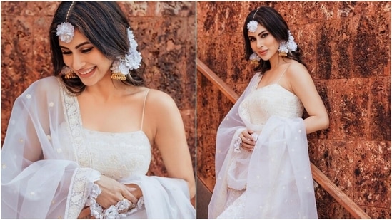 Mouni looked breathtaking in an all-white traditional look for her Haldi ceremony. The Brahmastra actor wore a spaghetti-strapped Anarkali suit that matched her minimalistic and elegant sartorial sense. It features barely-there straps, chikankari embroidery, sequinned work, a square neckline, and a heavy ghera.(Instagram/@imouniroy)