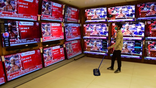 A boy cleans the floor while watching the live telecast of finance minister Nirmala Sitharaman's Budget speech, at a showroom in Mumbai on Tuesday.(PTI Photo)