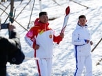 Torchbearer Qi Fabao, a regimental commander in the People's Liberation Army, relays the Olympic flame at the Winter Olympic Park.&nbsp;