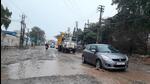 Commuters making way through a potholed road in Dera Bassi. As Punjab assembly polls nears, as part of their election campaigns, candidates are only busy with allegations and counter-allegations. (HT Photo)