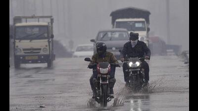 Commuters braving the rain on Dholewal overbridge in Ludhiana on Thursday. (Gurpreet Singh/HT)