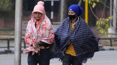 Women bundled in woollens near Sukhna Lake, Chandigarh, on a rainy Thursday morning. (Ravi Kumar/HT)