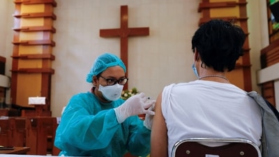 A health care worker injects the booster dose against coronavirus disease into a man's arm in Jakarta, Indonesia. (Reuters Photo)