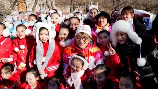 Jackie Chan poses for photos with children after taking part in the torch relay of the 2022 Winter Olympics at the Badaling Great Wall.(AP)