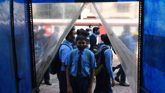 Students of Scottish Church Collegiate School, Kolkata, West Bengal get fully sanitized with a sanitizer tunnel before entering the school premises, (HT Photo/Samir Jana)