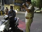 File photo of police stopping a man on two-wheeler during a night curfew.&nbsp;