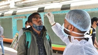 A healthcare worker collects swab samples for Covid-19 test of passengers arriving on outstation trains, at Dadar station, in Mumbai, India, on Thursday. (Bhushan Koyande/ HT Photo)
