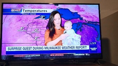 The image shows the meteorologist mom working from home holding her baby. (Screengrab)