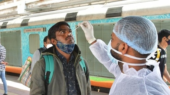 A healthcare worker collects swab samples for Covid-19 test of passengers arriving on outstation trains, at Dadar station, in Mumbai, India, on Thursday. (Bhushan Koyande/ HT Photo)