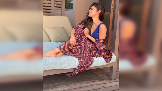 Mouni Roy cannot stop smiling as she poses on a poolside lounge chair.(Instagram/@imouniroy)