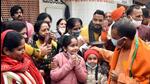 Chief minister Yogi Adityanath interacts with children during his visit to Gopal Mandir, in Gorakhpur where he conducted a doorstep campaign for the UP polls on Saturday. (PTI PHOTO)