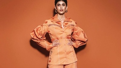 The pictures featured the diva donning an orange shirt top that came with a buttoned-down front and dramatic voluminous full sleeves. It was teamed with a pair of matching trousers and both the garments were made of organza and organic cotton while sporting beautiful florals and intricate designs that spoke the language of love. (Instagram/vandafashionagency) The pictures featured the diva donning an orange shirt top that came with a buttoned-down front and dramatic voluminous full sleeves. It was teamed with a pair of matching trousers and both the garments were made of organza and organic cotton while sporting beautiful florals and intricate designs that spoke the language of love. (Instagram/vandafashionagency)