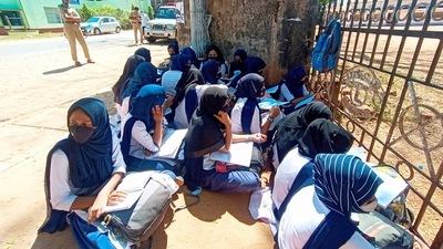 Kundapura students wearing hijab sit outside their school as the school authorities denied entry for wearing a hijab or scarf in Kundapura of Udupi. (PTI)