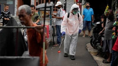 An Indonesian healthcare worker sprays disinfectant amid fears of another wave of the Covid-19 outbreak at a locality in Jakarta, Indonesia. (AP Photo)