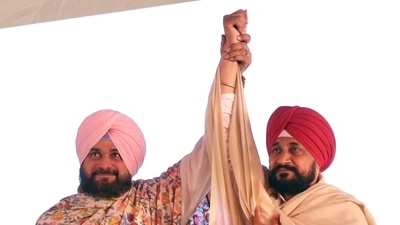 Congress Chief Ministerial candidate for Punjab Assembly elections Charanjit Singh Channi and Punjab Congress Chief Navjot Singh Sidhu raise hands at the virtual rally, in Ludhiana on Sunday. (ANI Photo)