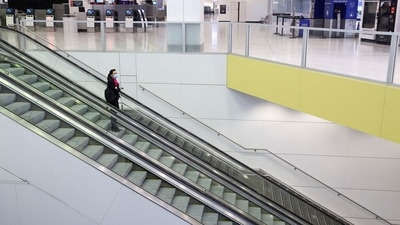 A flight crew member stands on an escalator in the international terminal at Sydney Airport. (Reuters / File)