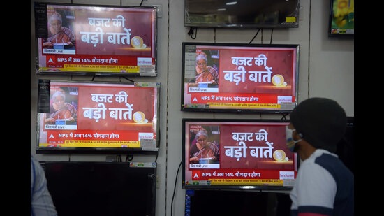 People watch Union Budget being presented by Finance Minister Nirmala Sitharaman in the Parliament at an electronics store (REPRESENTATIVE IMAGE)