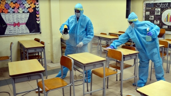 In picture - Workers sanitising a classroom at a school ahead of its reopening in Gurugram on Monday.(PTI) In picture - Workers sanitising a classroom at a school ahead of its reopening in Gurugram on Monday.(PTI)