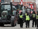 Police officers walk past parked tractors, as truckers and supporters continue to protest coronavirus disease (COVID-19) vaccine mandates, in Ottawa, Ontario, Canada.