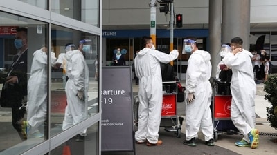 Travellers wear personal protective equipment outside the international terminal at Sydney Airport. (Reuters / File)