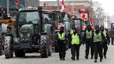 Police officers walk past parked tractors, as truckers and supporters continue to protest coronavirus disease (COVID-19) vaccine mandates, in Ottawa, Ontario, Canada. (REUTERS)