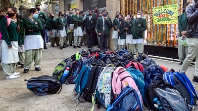 Bags kept for sanitisation as students wait to enter classrooms after schools reopened for 9th to 12th standard students, following ease in Covid-induced restrictions in New Delhi on Monday. (PTI Photo)
