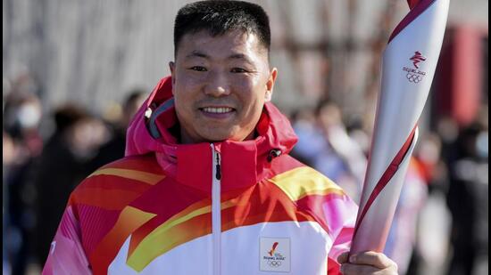 Torch bearer Qi Fabao takes part in the torch relay for the 2022 Winter Olympics at an Olympics Park in Beijing. India won’t be sending its top diplomat in Beijing to the Winter Olympics after the honour of carrying the Olympic torch went to a Chinese soldier wounded in a deadly border clash between the countries two years ago. (AP)