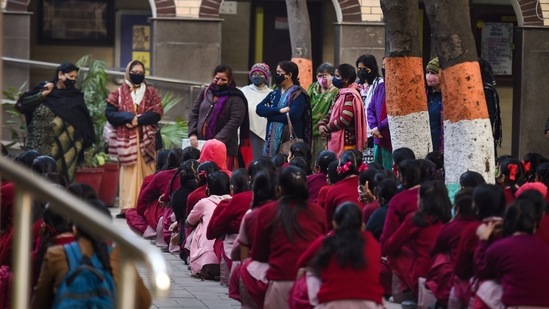 Children were seen wearing masks as they returned to school. At one private school, students' bags were being sanitised as part of precautionary measures against Covid-19.(PTI )