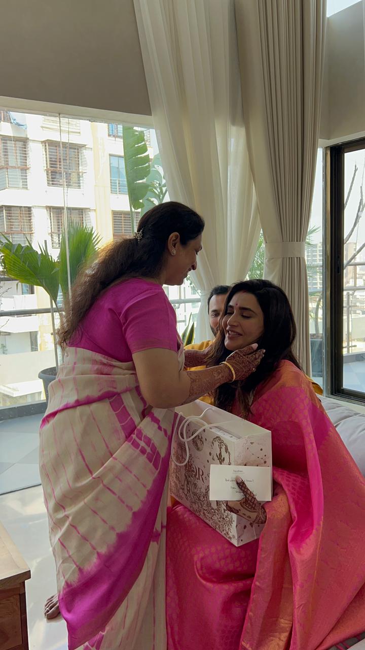 Karishma Tanna and Varun Bangera's mother share a moment as Varun looks on.