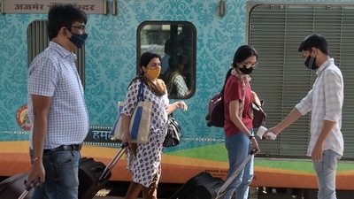 A health worker check temperature of passengers arriving on outstation trains at Dadar station, in Mumbai. (Satish Bate/HT PHOTO)