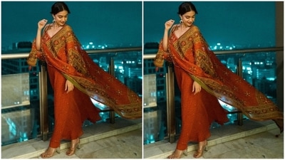 Keerthy styled the contemporary look by teaming it with minimal accessories. She chose statement gold earrings, rings and clear peep-toe sandals. Bold red lip shade, sleek eyeliner, kohl-adorned eyes, mascara on the lashes, dewy make-up, blushed cheeks, and a dainty bindi completed the glam picks. (Instagram/@keerthysureshofficial) Keerthy styled the contemporary look by teaming it with minimal accessories. She chose statement gold earrings, rings and clear peep-toe sandals. Bold red lip shade, sleek eyeliner, kohl-adorned eyes, mascara on the lashes, dewy make-up, blushed cheeks, and a dainty bindi completed the glam picks. (Instagram/@keerthysureshofficial)