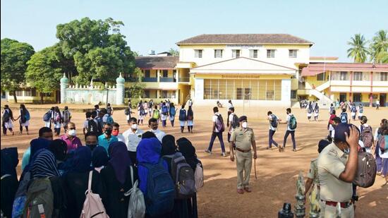 The principal of the college speaking with hijab-clad students. (AFP)